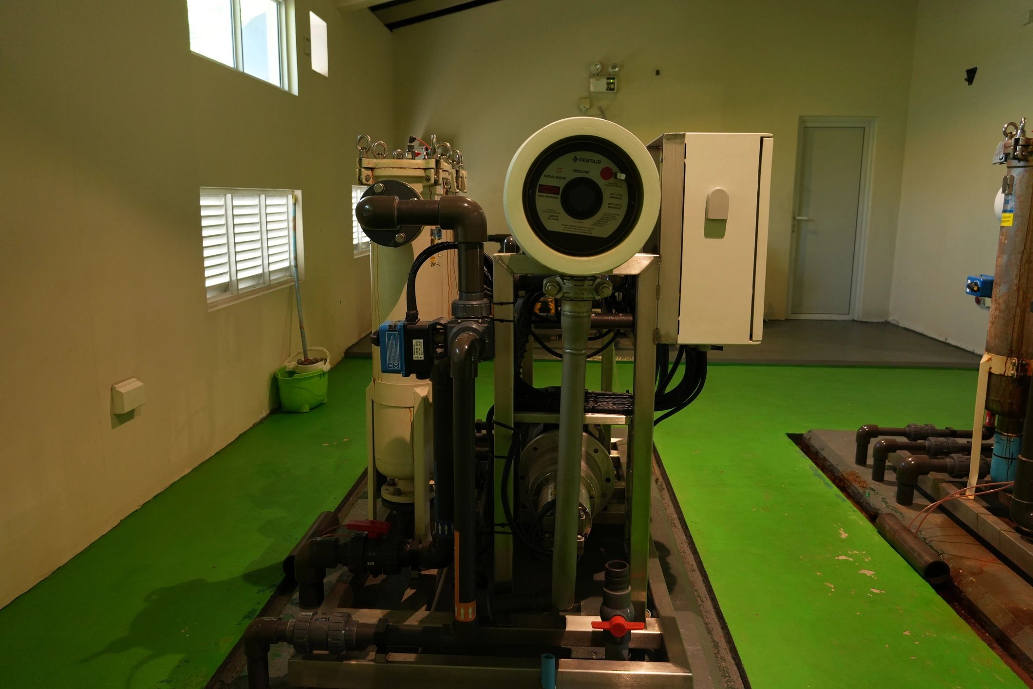Industrial water treatment plant room with machinery and piping